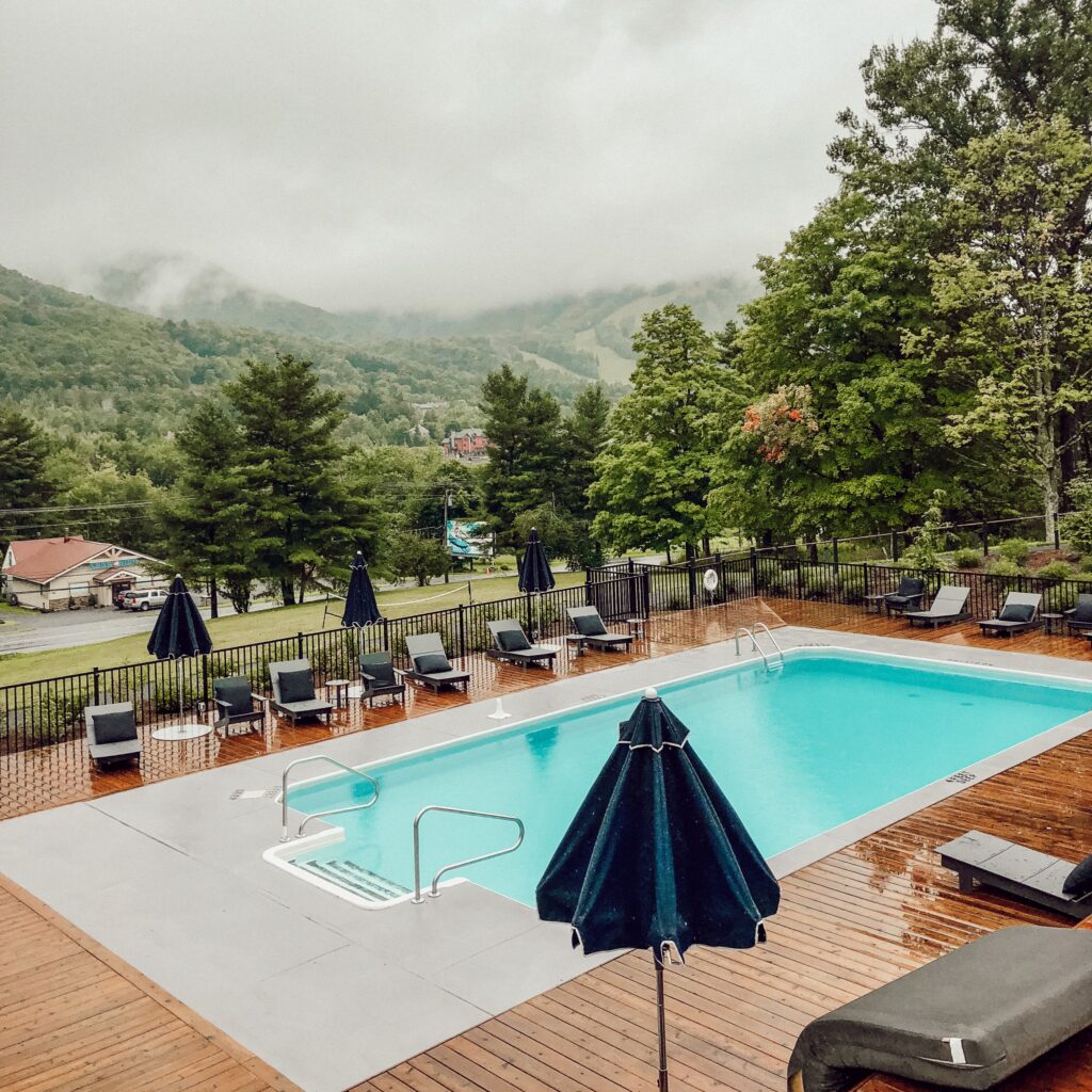 A serene swimming pool surrounded by lush greenery at a resort in New York.